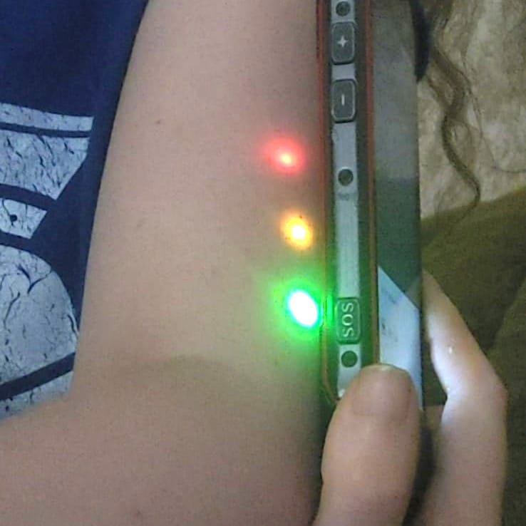 Brazo con implante NFC xSIID subcutáneo; LEDs rojo, ámbar y verde activados por móvil